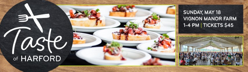 A promotional banner for 'Taste of Harford,' a food event. The banner features an image of plated appetizers, specifically bruschetta topped with diced tomatoes and herbs. The event details are displayed in a black box with white text: 'Sunday, May 18, Vignon Manor Farm, 1-4 PM | Tickets $45.' Another image on the right shows a large crowd gathered under a spacious event tent. The design includes a black circular logo with a fork and knife crossed above the words Taste of Harford.